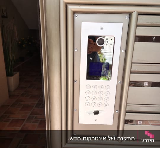 פאנל אינטרקום עם מצלמה ומקשים על דלת כניסה